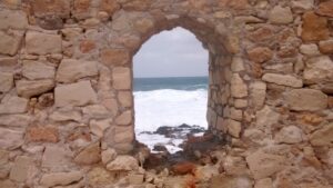 Looking through one of the arches in the harbour wall leading to Chania lighthouse
