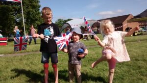 Ralph, Neve & Arthur waving their union jack flags at the Jubilee party